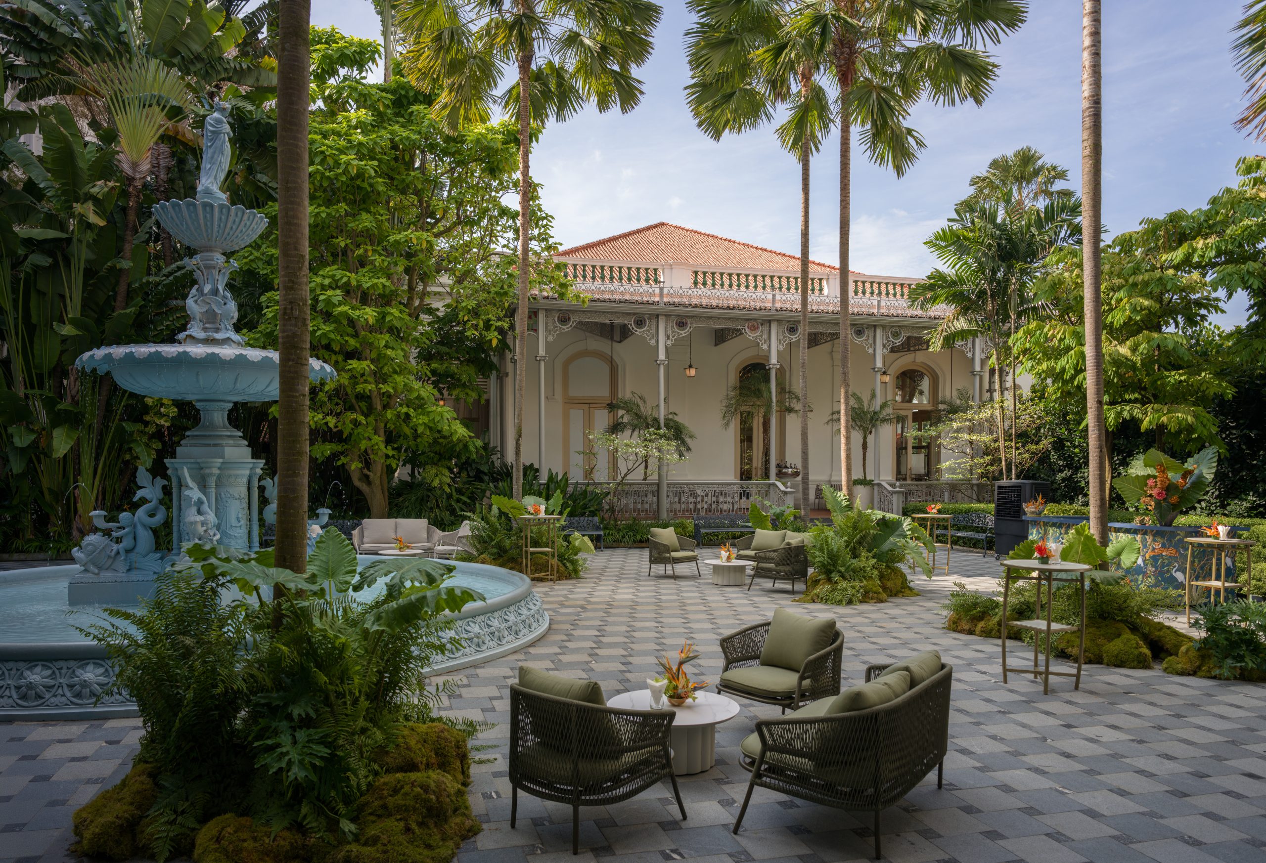 Luxury outdoor courtyard with fountain, tropical garden seating, and colonial-style villa architecture