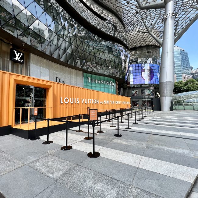 Luxury retail storefront with Louis Vuitton and Tiffany & Co displays in a modern glass architectural shopping complex