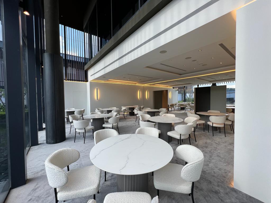 Modern indoor event dining setup with round tables and minimalist seating in a luxury venue