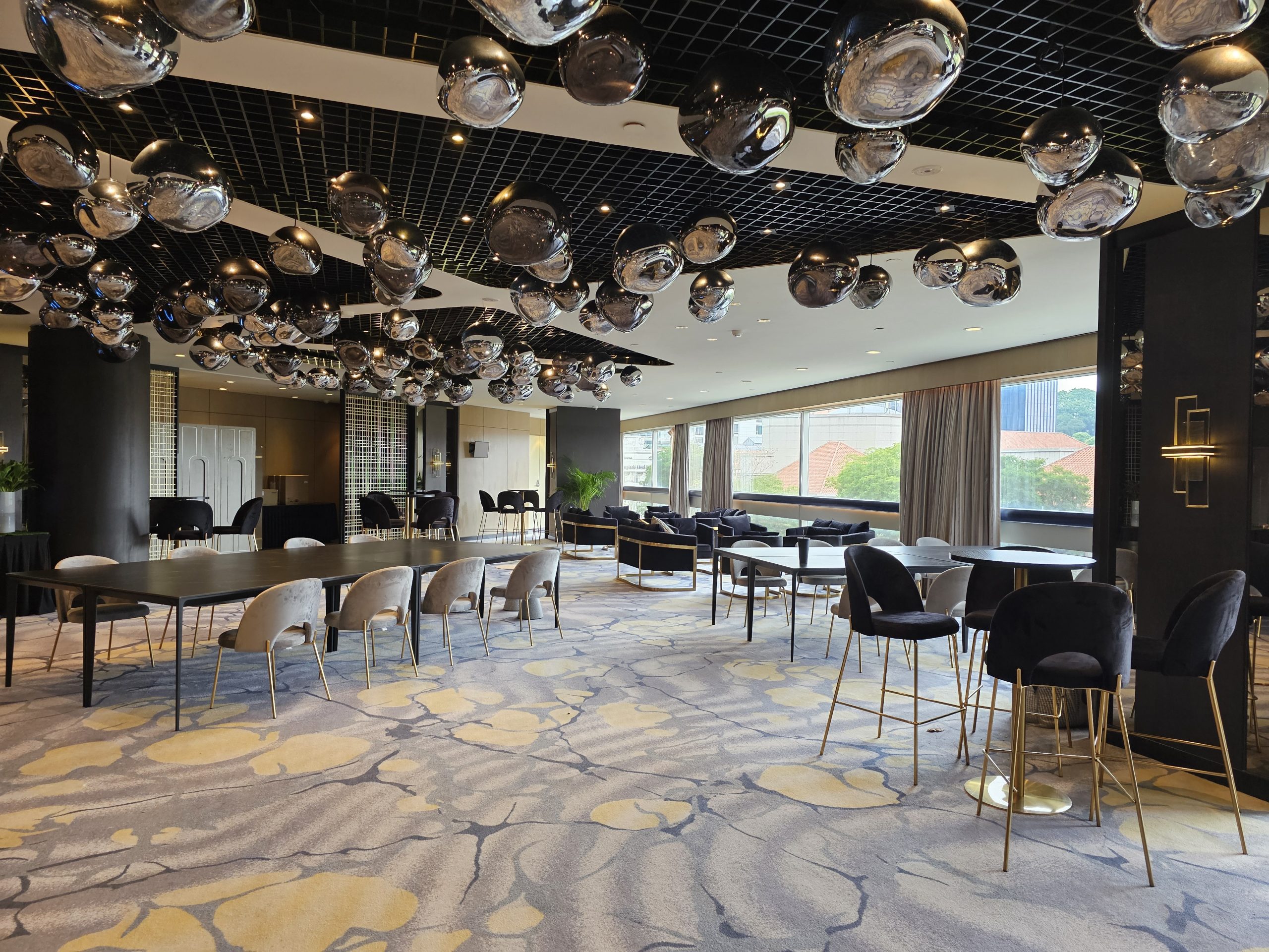 Luxury indoor event lounge with modern seating, designer lighting installation, and contemporary corporate setup