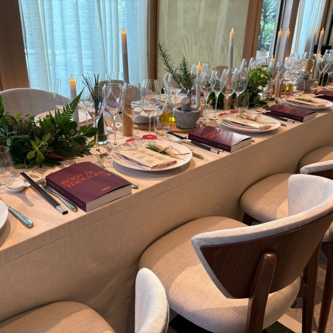 Elegant fine dining table setup with candles, greenery decor, and luxury place settings for a private event