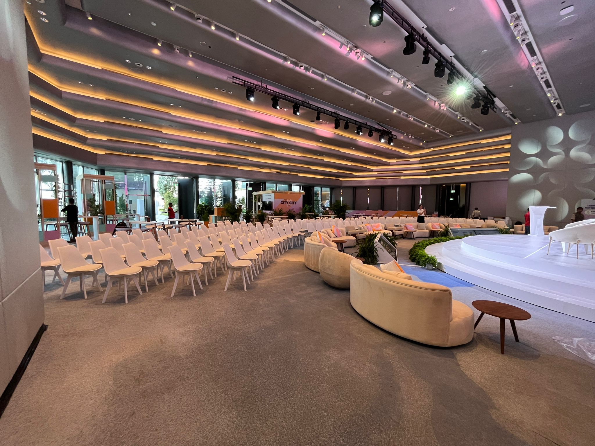 Modern conference event setup with stage, seating arrangement, and ambient lighting in a large venue