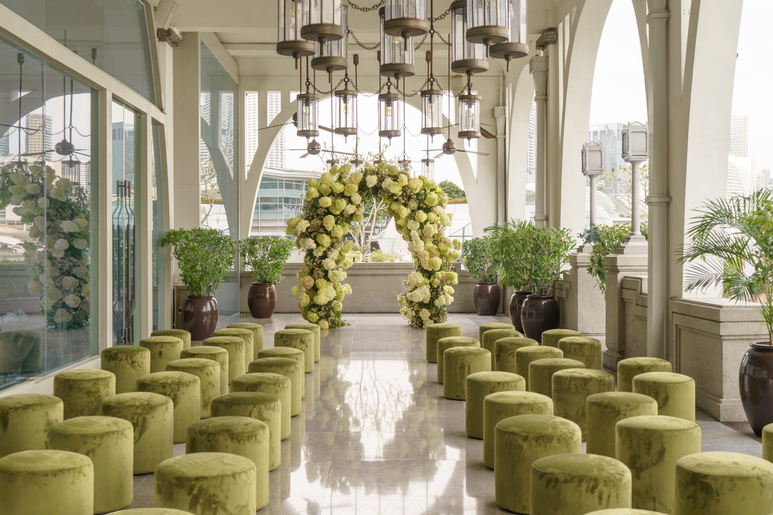 Elegant wedding ceremony setup with floral arch, aisle seating, and modern indoor venue design