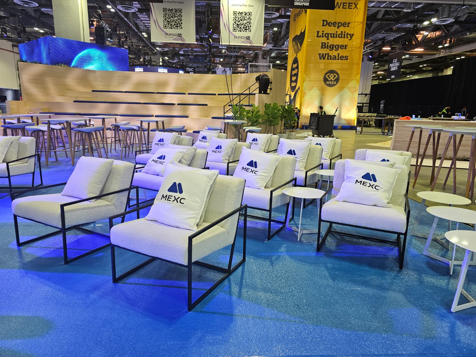 MEXC branded lounge seating area at crypto conference with modern chairs and networking setup