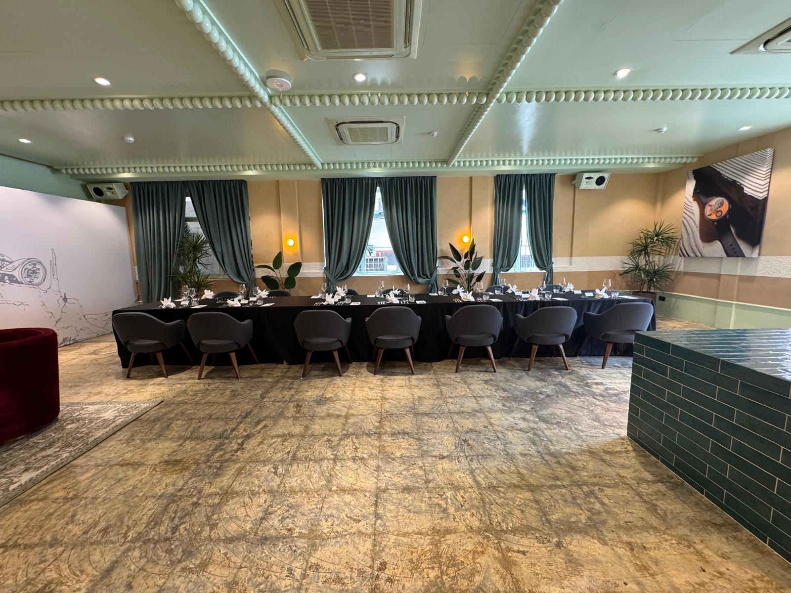 Elegant private dining setup with long table arrangement, modern chairs, and ambient indoor event decor